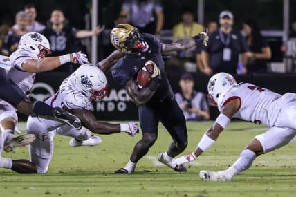 Sep 9, 2022; Orlando, Florida, USA; UCF Knights running back Jordan McDonald (9) is tackled by Louisville Cardinals linebacker Yasir Abdullah (22) during the second quarter at FBC Mortgage Stadium. Mandatory Credit: Mike Watters-USA TODAY Sports