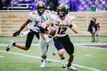 Missouri quarterback Brady Cook (12) runs away from a Kansas State defender during a game against Kansas State at Bill Snyder Family Stadium in Manhattan, Kansas, on Sept. 10, 2022.