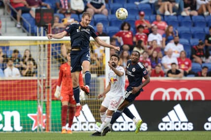 Sep 10, 2022; Harrison, New Jersey, USA; New England Revolution defender Henry Kessler (4) heads the ball away from New York Red Bulls midfielder Luquinhas (82) during the first half at Red Bull Arena. Mandatory Credit: Vincent Carchietta-USA TODAY Sports