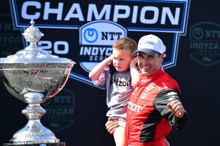 Sep 11, 2022; Salinas, California, USA; Team Penske driver Will Power (12) of Australia with son Beau William celebrates his series victory following the Grand Prix of Monterey at WeatherTech Raceway Laguna Seca. Mandatory Credit: Gary A. Vasquez-USA TODAY Sports