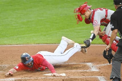 Sep 12, 2022; Cleveland, Ohio, USA; Cleveland Guardians catcher Austin Hedges (17) scores beside Los Angeles Angels catcher Max Stassi (33) in the second inning at Progressive Field. Mandatory Credit: David Richard-USA TODAY Sports