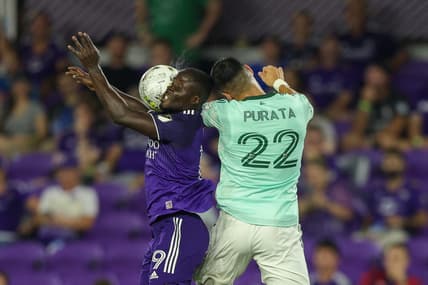 Sep 14, 2022; Orlando, Florida, USA;  Orlando City forward Benji Michel (19) and Atlanta United defender Juan Jose Purata (22) jumps fro a header in the second half at Exploria Stadium. Mandatory Credit: Nathan Ray Seebeck-USA TODAY Sports
