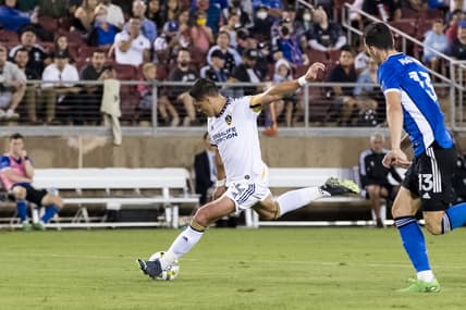 Sep 24, 2022; Stanford, California, USA; Los Angeles Galaxy forward Javier Hern  ndez (14) shoots and scores a goal as San Jose Earthquakes defender Nathan (13) defends during the second half at Stanford Stadium. Mandatory Credit: John Hefti-USA TODAY Sports