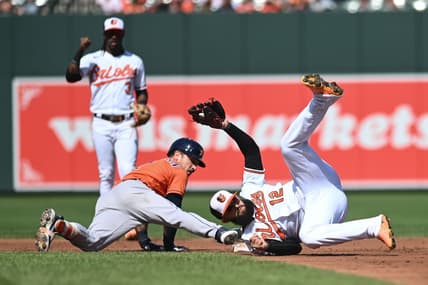 Sep 25, 2022; Baltimore, Maryland, USA;  Baltimore Orioles second baseman Rougned Odor (12) rolls after tagging out a sliding Houston Astros third baseman Alex Bregman (2) in the second inning at Oriole Park at Camden Yards. Mandatory Credit: Tommy Gilligan-USA TODAY Sports