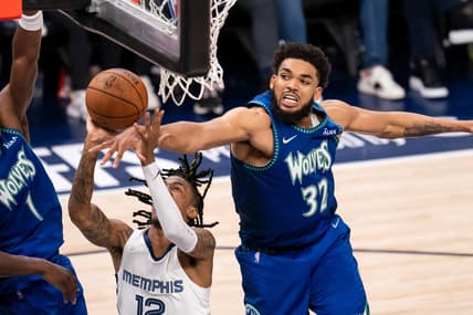 Apr 29, 2022; Minneapolis, Minnesota, USA; Minnesota Timberwolves center Karl-Anthony Towns (32) blocks Memphis Grizzlies guard Ja Morant (12) in the fourth quarter during game six of the first round for the 2022 NBA playoffs at Target Center. Mandatory Credit: Brad Rempel-USA TODAY Sports