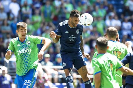 Jun 25, 2022; Seattle, Washington, USA; Sporting Kansas City forward Khiry Shelton (11) heads away a corner kick against Seattle Sounders FC defender Jackson Ragen (25) during the first half at Lumen Field. Mandatory Credit: Joe Nicholson-USA TODAY Sports