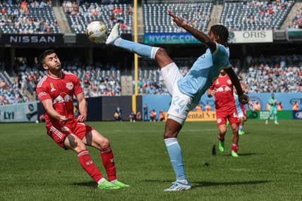 Sep 17, 2022; New York, New York, USA; New York City FC defender Tayvon Gray (24) kicks the ball against New York Red Bulls midfielder Lewis Morgan (10) at Yankee Stadium. Mandatory Credit: Vincent Carchietta-USA TODAY Sports