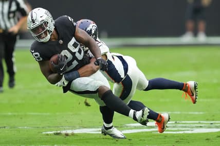 Oct 2, 2022; Paradise, Nevada, USA; Las Vegas Raiders running back Josh Jacobs (28) is tackled by Denver Broncos cornerback K'Waun Williams (21) during a game at Allegiant Stadium. Mandatory Credit: Stephen R. Sylvanie-USA TODAY Sports