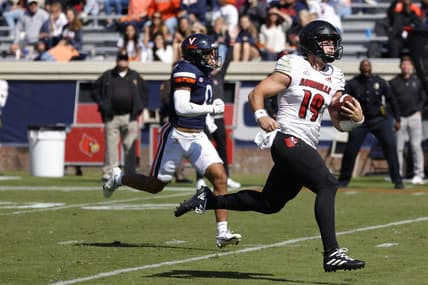 Oct 8, 2022; Charlottesville, Virginia, USA; Louisville Cardinals quarterback Brock Domann (19) scores a touchdown as Virginia Cavaliers safety Antonio Clary (0) chases during the second quarter at Scott Stadium. Mandatory Credit: Geoff Burke-USA TODAY Sports