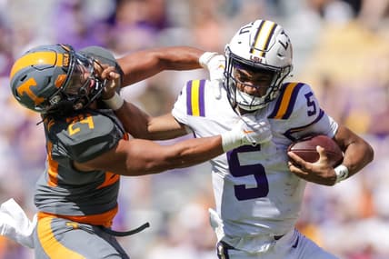 Oct 8, 2022; Baton Rouge, Louisiana, USA;  LSU Tigers quarterback Jayden Daniels (5) stiff arms Tennessee Volunteers linebacker Aaron Beasley (24) as he tries to tackle him during the second half at Tiger Stadium. Mandatory Credit: Stephen Lew-USA TODAY Sports