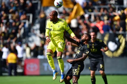 Oct 9, 2022; Los Angeles, California, USA; Nashville SC forward Teal Bunbury (12) plays for the ball against Los Angeles FC midfielder Kellyn Acosta (23) during the first half at Banc of California Stadium. Mandatory Credit: Gary A. Vasquez-USA TODAY Sports