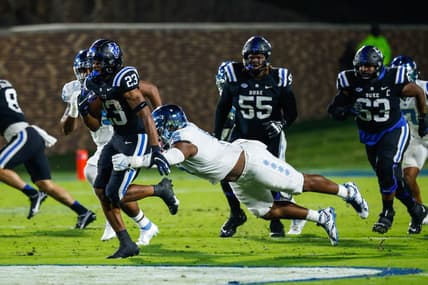 Oct 15, 2022; Durham, North Carolina, USA;  Duke Blue Devils running back Terry Moore (23) runs with the ball while North Carolina Tar Heels defensive lineman Jahvaree Ritzie (5) tries to tackle him during the first half at Wallace Wade Stadium. Mandatory Credit: Jaylynn Nash-USA TODAY Sports