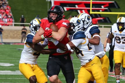 Oct 22, 2022; Lubbock, Texas, USA;  Texas Tech Red Raiders tight end Mason Tharp (80) is tackled by West Virginia Mountaineers defensive safety Marcis Floyd (24), defensive corner back Rashad Ajayi (4) and defensive linebacker Jasir Cox (7) in the first half at Jones AT&T Stadium and Cody Campbell Field. Mandatory Credit: Michael C. Johnson-USA TODAY Sports