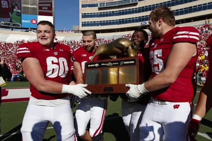 Oct 30, 2021; Madison, Wisconsin, USA; Wisconsin Badgers players celebrate with the Heartland Trophy following the game against the Iowa Hawkeyes at Camp Randall Stadium. Mandatory Credit: Jeff Hanisch-USA TODAY Sports