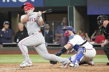 Apr 15, 2022; Arlington, Texas, USA; Los Angeles Angels center fielder Mike Trout follows through on his swing for an infield hit against the Texas Rangers during the third inning of a baseball game at Globe Life Field. Mandatory Credit: Jim Cowsert-USA TODAY Sports