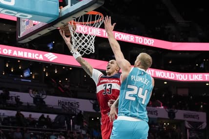 Nov 7, 2022; Charlotte, North Carolina, USA; Washington Wizards forward Kyle Kuzma (33) goes to the basket defended by Charlotte Hornets center Mason Plumlee (24) during the second half at Spectrum Center. Mandatory Credit: Jim Dedmon-USA TODAY Sports