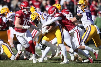 Nov 12, 2022; Fayetteville, Arkansas, USA; LSU Tigers running back Noah Cain (21) is tackled by Arkansas Razorbacks defensive back Hudson Clark (17) and linebacker Bumper Poole (10) during the second quarter at Donald W. Reynolds Razorback Stadium. Mandatory Credit: Nelson Chenault-USA TODAY Sports