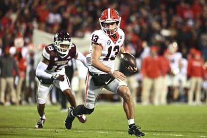 Nov 12, 2022; Starkville, Mississippi, USA; Georgia Bulldogs quarterback Stetson Bennett (13) runs the ball againstMississippi State Bulldogs safety Collin Duncan (19) during the second quarter at Davis Wade Stadium at Scott Field. Mandatory Credit: Matt Bush-USA TODAY Sports