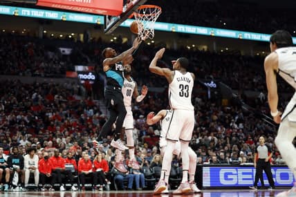 Nov 17, 2022; Portland, Oregon, USA; Portland Trail Blazers point guard Damian Lillard (0) is fouled while shooting by Brooklyn Nets power forward Royce O'Neale (00) during the first half at Moda Center. Mandatory Credit: Soobum Im-USA TODAY Sports