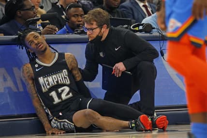 Nov 18, 2022; Memphis, Tennessee, USA; Memphis Grizzlies guard Ja Morant (12) is checked by a staff member after limping off the court during the second half against the Oklahoma City Thunder at FedExForum. Mandatory Credit: Petre Thomas-USA TODAY Sports