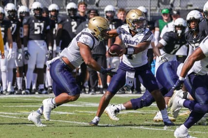 Nov 19, 2022; Orlando, Florida, USA; Navy Midshipmen quarterback Xavier Arline (7) hands off to Navy Midshipmen fullback Daba Fofana (45) during the first quarter at FBC Mortgage Stadium. Mandatory Credit: Mike Watters-USA TODAY Sports
