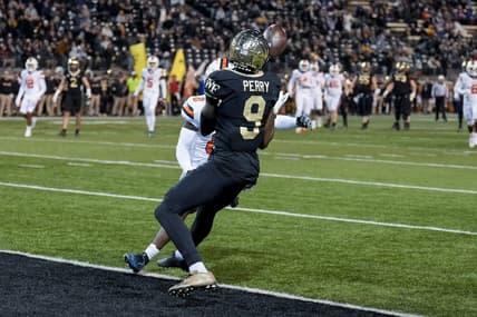 Nov 19, 2022; Winston-Salem, North Carolina, USA; Wake Forest Demon Deacons wide receiver A.T. Perry (9) makes a catch against Syracuse Orange defensive back Darian Chestnut (0) to score during the first half at Truist Field. Mandatory Credit: Jim Dedmon-USA TODAY Sports