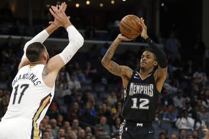 Nov 25, 2022; Memphis, Tennessee, USA; Memphis Grizzlies guard Ja Morant (12) shoots for three as New Orleans Pelicans center Jonas Valanciunas (17) defends during the first quarter at FedExForum. Mandatory Credit: Petre Thomas-USA TODAY Sports