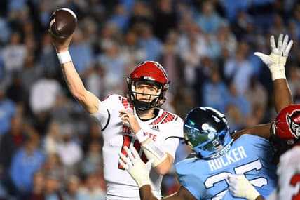 Nov 25, 2022; Chapel Hill, North Carolina, USA; North Carolina State Wolfpack quarterback Ben Finley (10) passes the ball as North Carolina Tar Heels defensive lineman Kaimon Rucker (25) defends in the fourth quarter at Kenan Memorial Stadium. Mandatory Credit: Bob Donnan-USA TODAY Sports