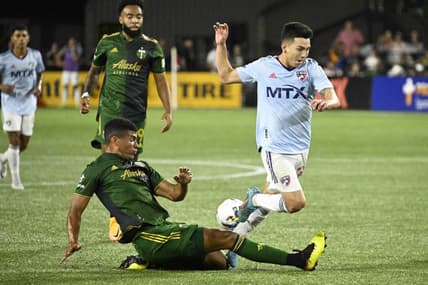 Aug 6, 2022; Portland, Oregon, USA; Portland Timbers defender Zac McGraw (18) slide tackles FC Dallas forward Alan Velasco (20) during the second half at Providence Park. The game ended tied 1-1. Mandatory Credit: Troy Wayrynen-USA TODAY Sports