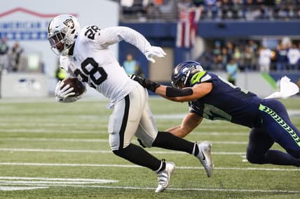 Nov 27, 2022; Seattle, Washington, USA; Las Vegas Raiders running back Josh Jacobs (28) breaks a tackle attempt by Seattle Seahawks linebacker Cody Barton (57) after making a reception during the fourth quarter at Lumen Field. Mandatory Credit: Joe Nicholson-USA TODAY Sports