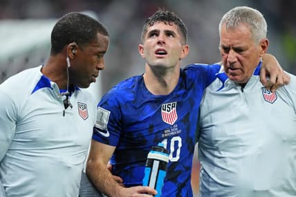 Nov 29, 2022; Doha, Qatar; United States of America forward Christian Pulisic (10) is helped after sustaining an injury after colliding with Iran goalkeeper Alireza Beiranvand (1) following his goal during the first half of a group stage match during the 2022 World Cup at Al Thumama Stadium. Mandatory Credit: Danielle Parhizkaran-USA TODAY Sports