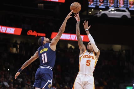 Dec 2, 2022; Atlanta, Georgia, USA; Atlanta Hawks guard Dejounte Murray (5) shoots over Denver Nuggets forward Bruce Brown (11) in the second quarter at State Farm Arena. Mandatory Credit: Brett Davis-USA TODAY Sports