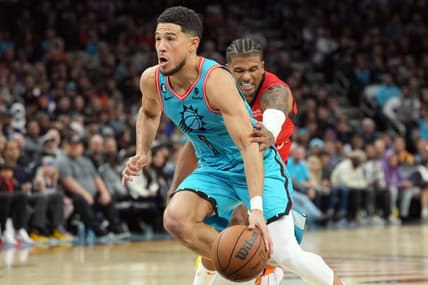 Dec 2, 2022; Phoenix, Arizona, USA; Phoenix Suns guard Devin Booker (1) dribbles by Houston Rockets guard Jalen Green (4) during the second half at Footprint Center. Mandatory Credit: Joe Camporeale-USA TODAY Sports