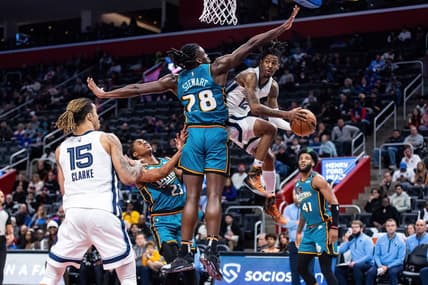 Dec 4, 2022; Detroit, Michigan, USA; Memphis Grizzlies guard Ja Morant (12) passes the ball around Detroit Pistons center Isaiah Stewart (28) in the second half at Little Caesars Arena. Mandatory Credit: Allison Farrand-USA TODAY Sports