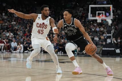 Dec 12, 2022; San Antonio, Texas, USA; San Antonio Spurs guard Devin Vassell (24) dribbles past Cleveland Cavaliers guard Donovan Mitchell (45) in the first half at the AT&T Center. Mandatory Credit: Daniel Dunn-USA TODAY Sports