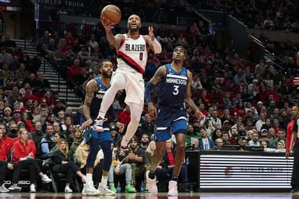 Dec 12, 2022; Portland, Oregon, USA;  Portland Trail Blazers guard Damian Lillard (0) scores a basket during the first half against Minnesota Timberwolves forward Jaden McDaniels (3) at Moda Center. Mandatory Credit: Troy Wayrynen-USA TODAY Sports