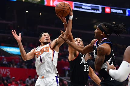Dec 15, 2022; Los Angeles, California, USA; Phoenix Suns guard Devin Booker (1) plays for the rebound against Los Angeles Clippers forward Nicolas Batum (33) and guard Terance Mann (14) during the first half at Crypto.com Arena. Mandatory Credit: Gary A. Vasquez-USA TODAY Sports