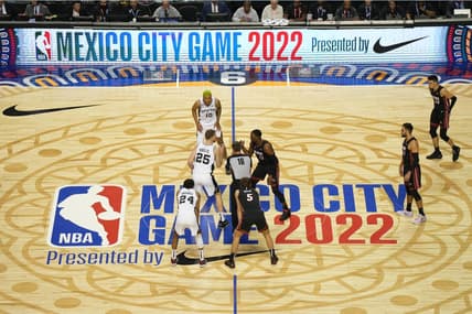 Dec 17, 2022; Mexico City, MEX; San Antonio Spurs center Jakob Poeltl (25) and Miami Heat center Bam Adebayo (13) await the opening tipoff from referee Matt Boland (18) during the NBA Mexico City Game 2022 at the Arena de Ciudad de Mexico. Mandatory Credit: Kirby Lee-USA TODAY Sports