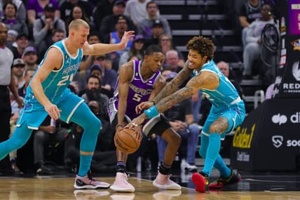 Dec 19, 2022; Sacramento, California, USA; Charlotte Hornets guard Kelly Oubre Jr. (12) steals the ball from Sacramento Kings guard De'Aaron Fox (5) during the first quarter at Golden 1 Center. Mandatory Credit: Sergio Estrada-USA TODAY Sports