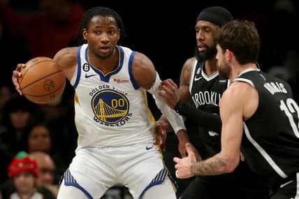 Dec 21, 2022; Brooklyn, New York, USA; Golden State Warriors forward Jonathan Kuminga (00) controls the ball against Brooklyn Nets forward Royce O'Neale (00) and forward Joe Harris (12) during the third quarter at Barclays Center. Mandatory Credit: Brad Penner-USA TODAY Sports