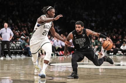 Dec 23, 2022; Brooklyn, New York, USA;  Brooklyn Nets guard Kyrie Irving (11) drives past Milwaukee Bucks guard Jrue Holiday (21) in the third quarter at Barclays Center. Mandatory Credit: Wendell Cruz-USA TODAY Sports
