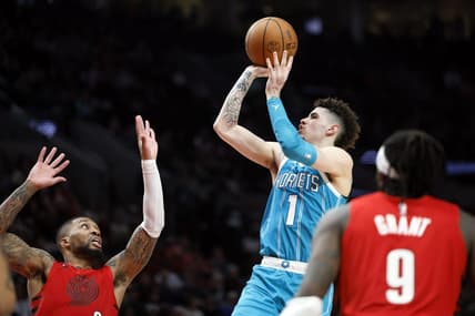 Dec 26, 2022; Portland, Oregon, USA; Charlotte Hornets point guard LaMelo Ball (1) shoots the ball over Portland Trail Blazers point guard Damian Lillard (0, left) during the second half at Moda Center. Mandatory Credit: Soobum Im-USA TODAY Sports