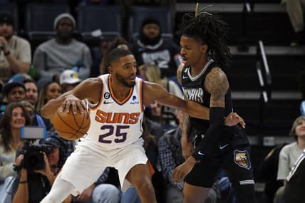Dec 27, 2022; Memphis, Tennessee, USA; Phoenix Suns forward Mikal Bridges (25) dribbles to the basket as Memphis Grizzlies guard Ja Morant (12) defends during the first half at FedExForum. Mandatory Credit: Petre Thomas-USA TODAY Sports