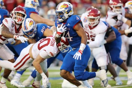 Dec 28, 2022; Memphis, TN, USA; Kansas Jayhawks running back Devin Neal (4) rushes against the Arkansas Razorbacks in the first quarter in the 2022 Liberty Bowl at Liberty Bowl Memorial Stadium. Mandatory Credit: Nelson Chenault-USA TODAY Sports