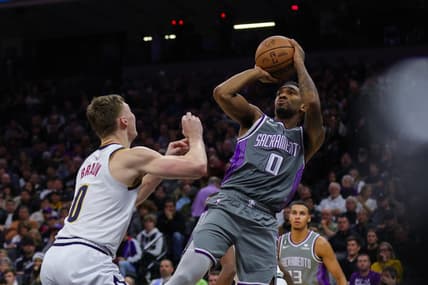 Dec 28, 2022; Sacramento, California, USA; Sacramento Kings guard Malik Monk (0) shoots the ball over Denver Nuggets guard Christian Braun (0) during the third quarter at Golden 1 Center. Mandatory Credit: Sergio Estrada-USA TODAY Sports