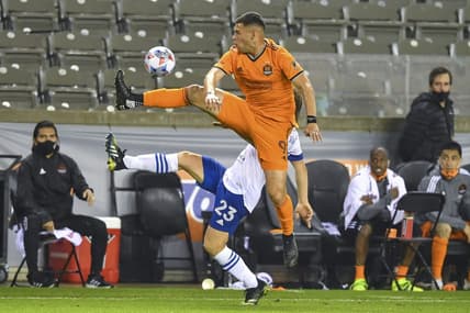 Apr 16, 2021; Houston, Texas, USA;  Houston Dynamo forward Christian Ramirez (9) and San Jose Earthquakes defender Florian Jungwirth (23) volley the ball during the second half at BBVA Stadium. Mandatory Credit: Maria Lysaker-USA TODAY Sports