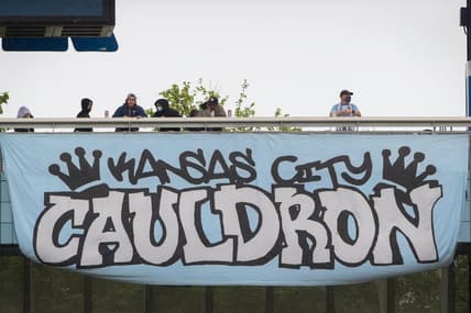 May 16, 2021; Kansas City, Kansas, USA;  fans stand on the balcony over one of the club banners during the game between the Sporting Kansas City and the Vancouver Whitecaps at Children's Mercy Park. Mandatory Credit: William Purnell-USA TODAY Sports