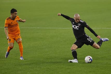 May 7, 2022; Washington, District of Columbia, USA; D.C. United defender Brad Smith (5) crosses the ball as Houston Dynamo midfielder Memo Rodr guez (8) defends in the second half at Audi Field. Mandatory Credit: Geoff Burke-USA TODAY Sports