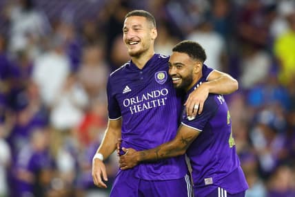 Jun 18, 2022; Orlando, Florida, USA;  Orlando City forward Ercan Kara (9) and midfielder Jake Mulraney (23) celebrate a goal against the Houston Dynamo in the second half at Exploria Stadium. Mandatory Credit: Nathan Ray Seebeck-USA TODAY Sports
