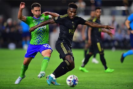 Jul 29, 2022; Los Angeles, California, USA; Los Angeles FC midfielder Daniel Crisostomo (20) moves the ball against Seattle Sounders midfielder Nicolas Lodeiro (10) during the first half at Banc of California Stadium. Mandatory Credit: Gary A. Vasquez-USA TODAY Sports